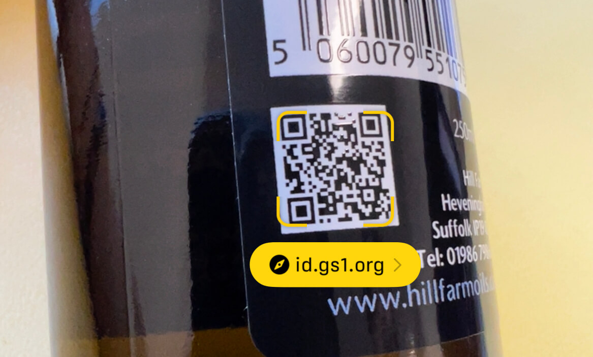 A user pointing an iPhone camera at a GS1 Digital Link QR code.